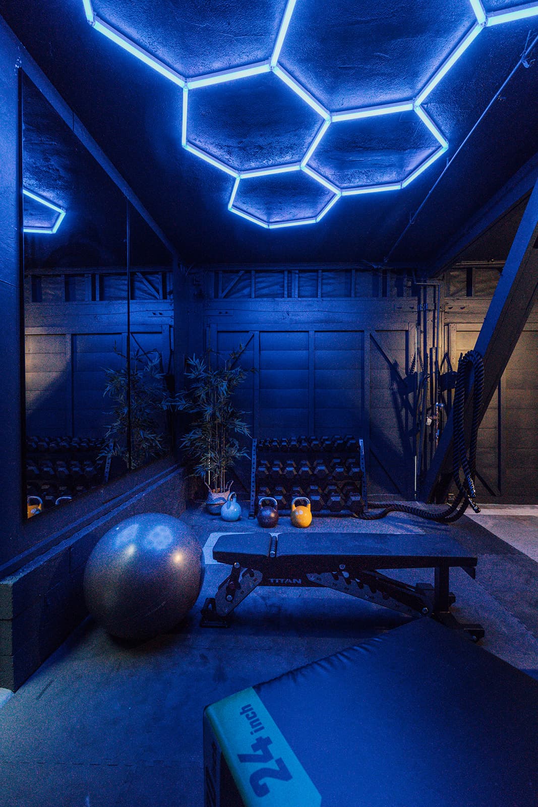 The gym: dumbbells and kettlebells racked along the wall